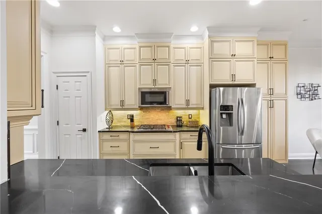 a kitchen with stainless steel appliances a refrigerator and a stove top oven