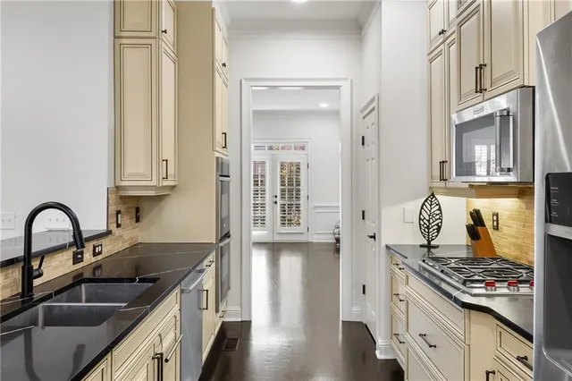 a kitchen with stainless steel appliances granite countertop a sink stove and cabinets