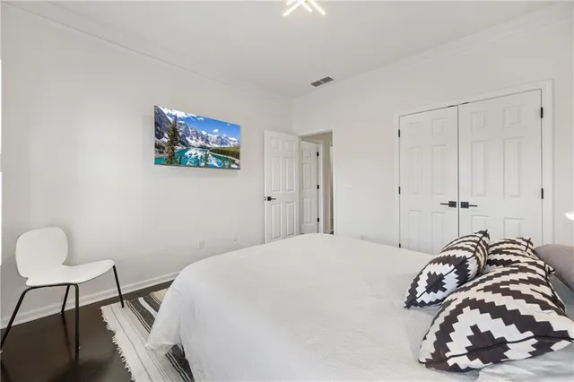 a bedroom with a bed a chair and a large window