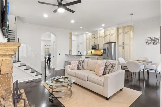 a living room with furniture kitchen view and a chandelier