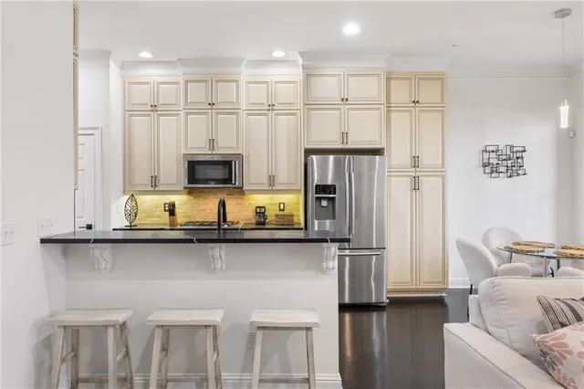 a kitchen with stainless steel appliances granite countertop a refrigerator a stove and a sink