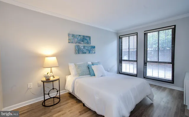 a bedroom with a bed a lamp and window