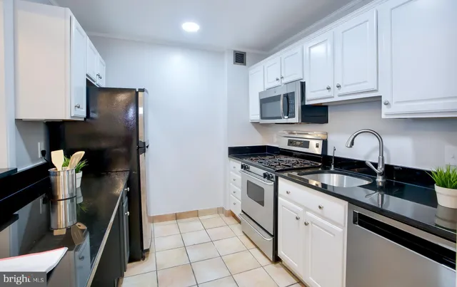 a kitchen with granite countertop a stove sink and cabinets