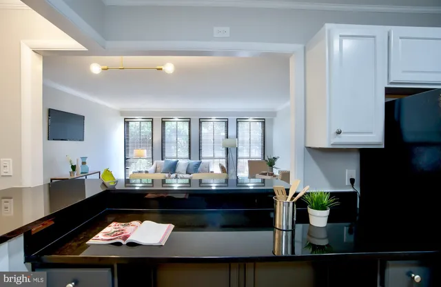 a view of kitchen island with granite countertop lots of clutter and stainless steel appliances