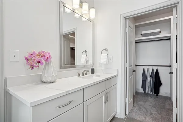 a bathroom with a sink vanity and a mirror