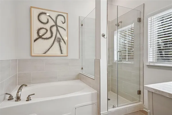 a white bath tub sitting next to a shower