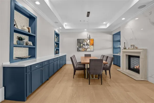 a dining room with furniture a floor to ceiling window and a kitchen
