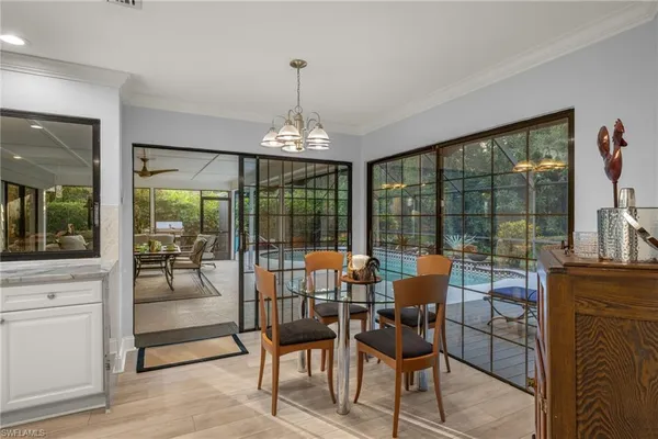 a dining room with furniture large windows and a chandelier