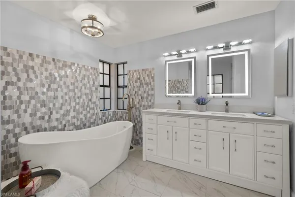 a bathroom with a bathtub sink and mirror
