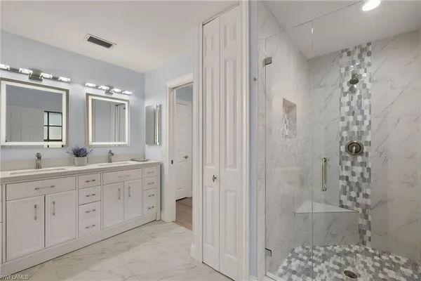 a spacious bathroom with a double vanity sink mirror and shower