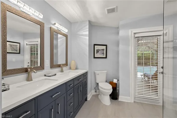 a bathroom with a double vanity sink and a window
