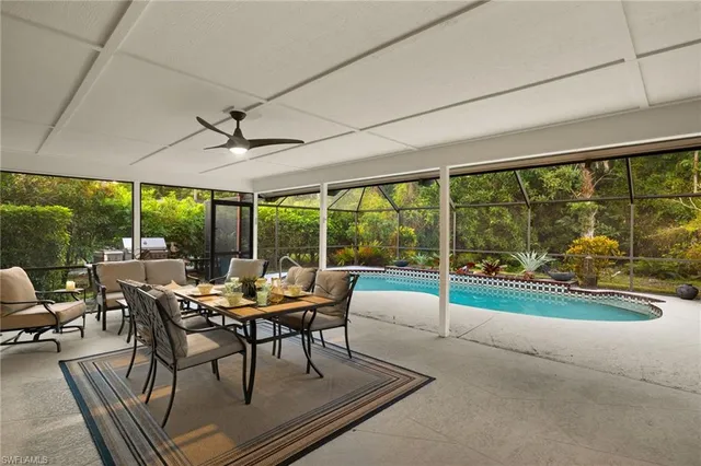 a dining room with furniture large windows and wooden floor