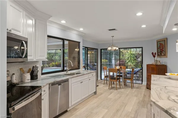 a kitchen with stainless steel appliances granite countertop sink stove and wooden cabinets