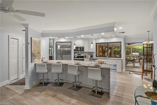 a kitchen with stainless steel appliances granite countertop a table and chairs in it