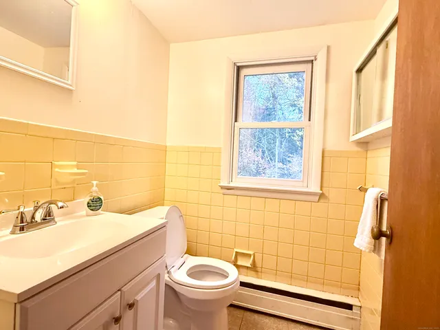 a bathroom with a sink mirror toilet and shower