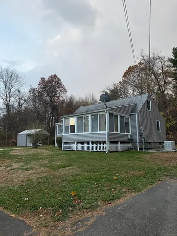 a house that has a big yard with plants and large trees