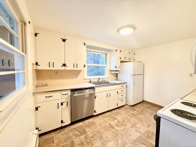 a kitchen with white cabinets and white appliances