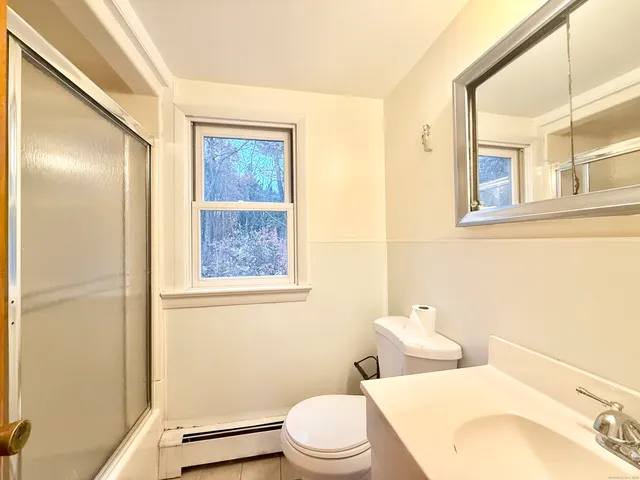 a bathroom with a toilet a sink and a mirror