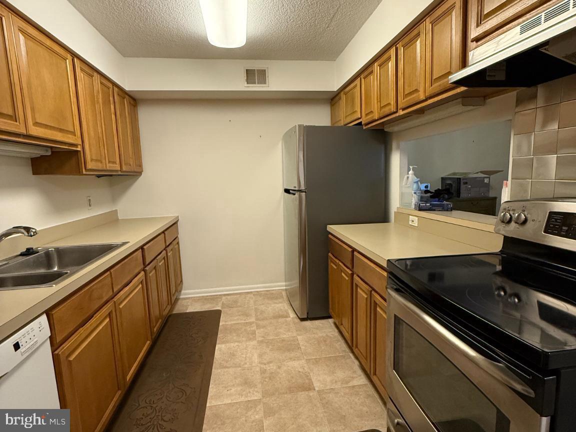 1420 Locust Street, Unit 11K Philadelphia, PA 19102 - Photo 6 of 11 Modern kitchen with warm wood tones.