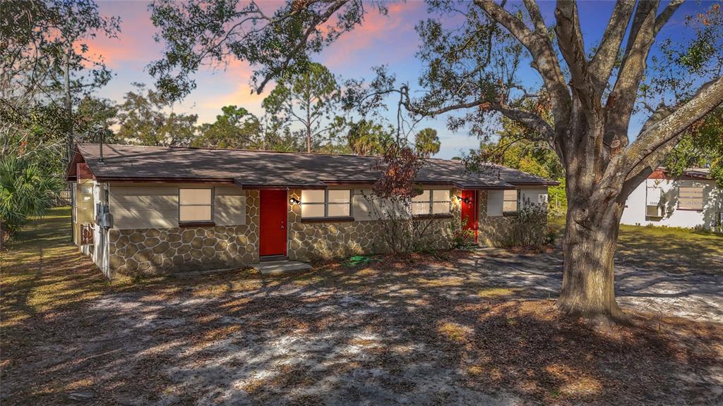 5510 Daniels Road Tampa, FL 33634 - Photo 1 of 1 a view of a house with large tree and wooden fence
