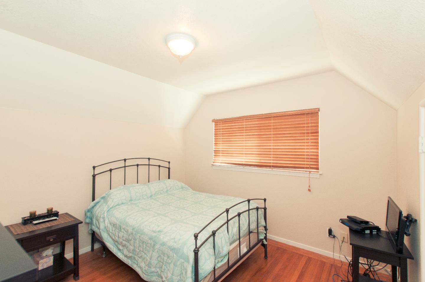 472 Inverness Drive Pacifica, CA 94044 - Photo 11 of 22 a bedroom with a bed next to a window with wooden floor