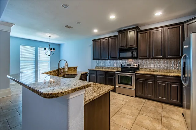a kitchen with granite countertop a stove and a sink