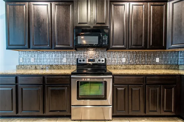 a view of granite countertop cabinets and stainless steel appliances