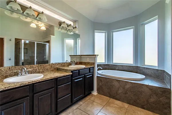 a large bathroom with a glass door shower and sink