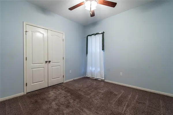 an empty room with a empty room and a chandelier fan