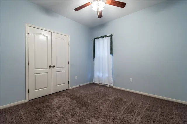 an empty room with a empty room and a chandelier fan