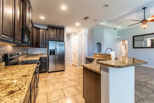 a kitchen with kitchen island granite countertop cabinets and refrigerator