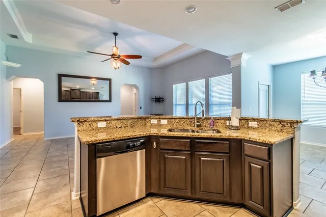 a kitchen with granite countertop a sink cabinets and stainless steel appliances