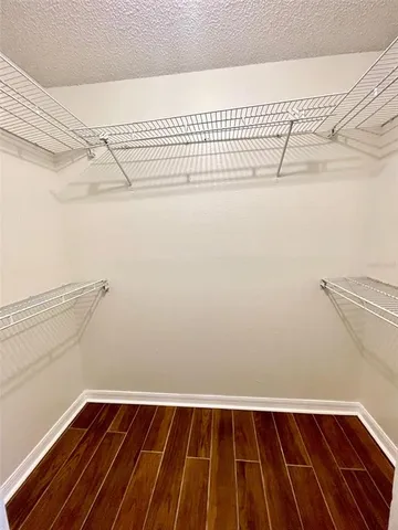 an empty room with wooden floor ceiling fan and windows