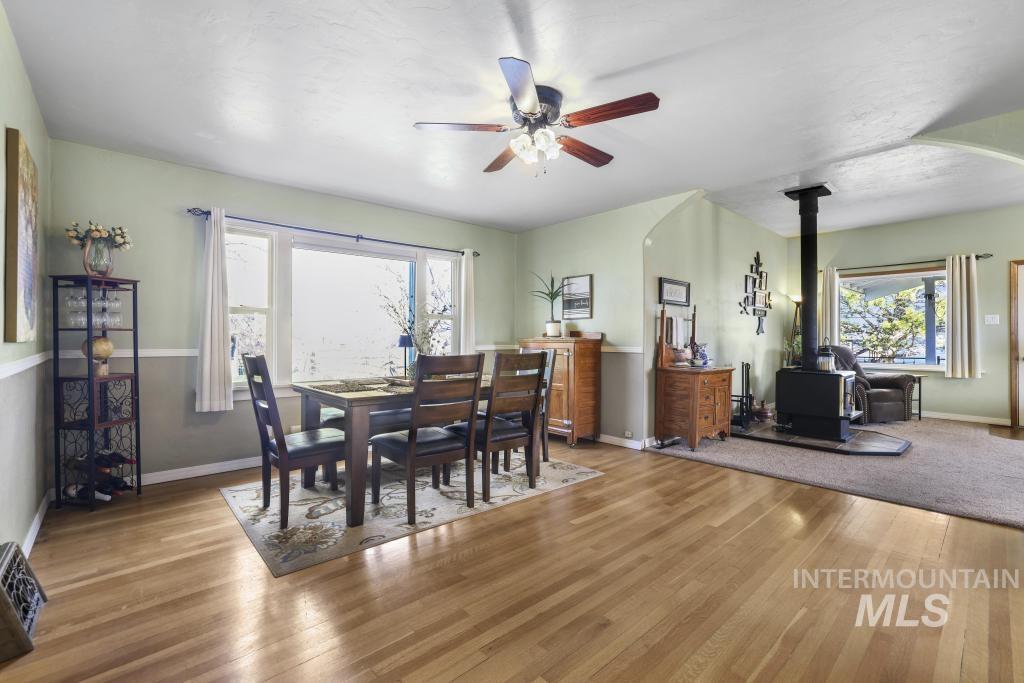 3985 North 2300 E Road Filer, ID 83328 - Photo 8 of 35 Dining area featuring ceiling fan, hardwood / wood-style flooring, and a wood stove