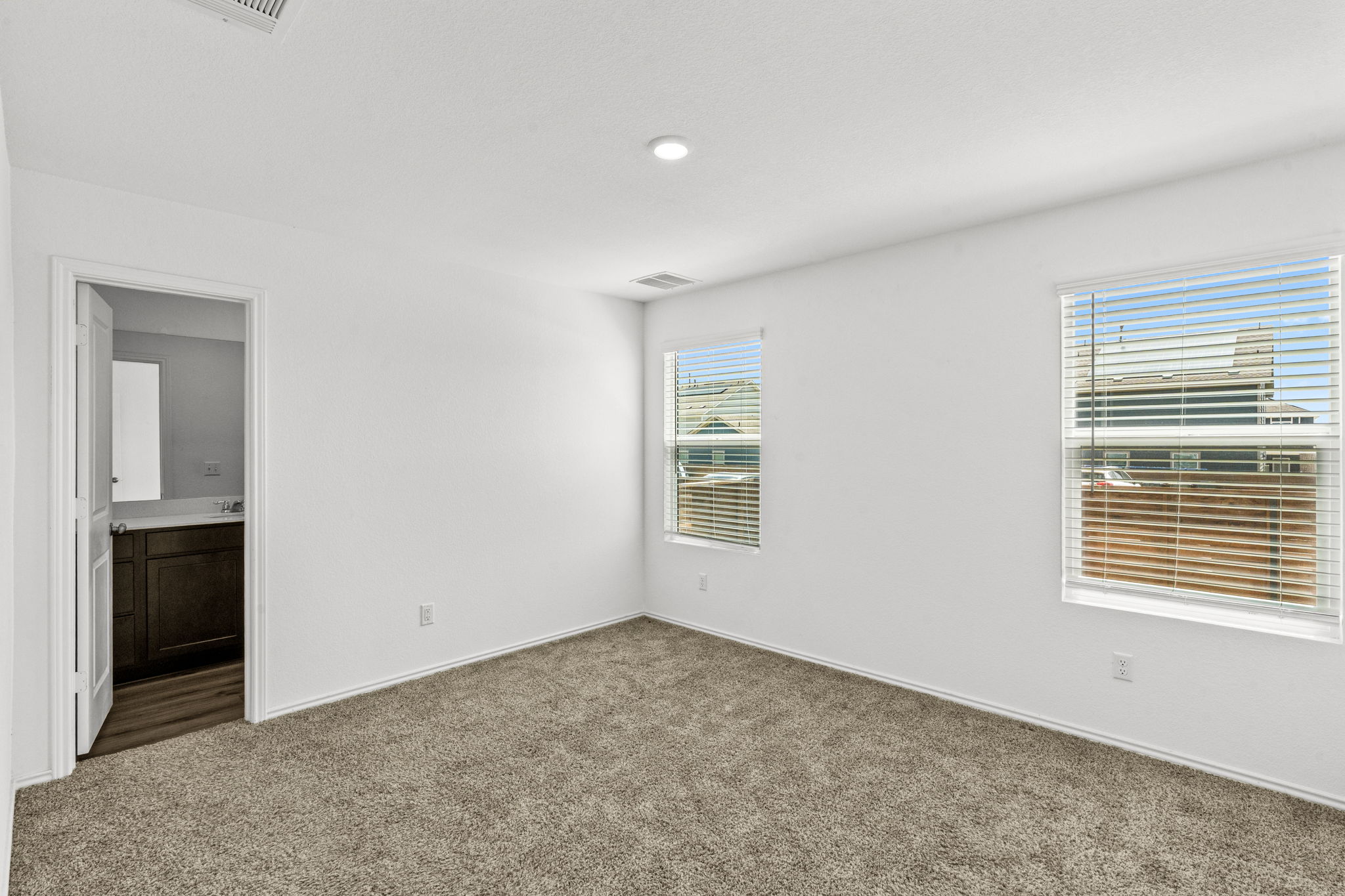 889 Powell Kyle, TX 78640 - Photo 10 of 22 Plentiful natural light streams through multiple windows into this carpeted bedroom suite.