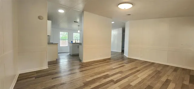 an empty room with wooden floor and a bathroom