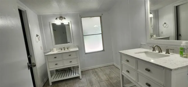 a bathroom with a granite countertop sink vanity and mirror