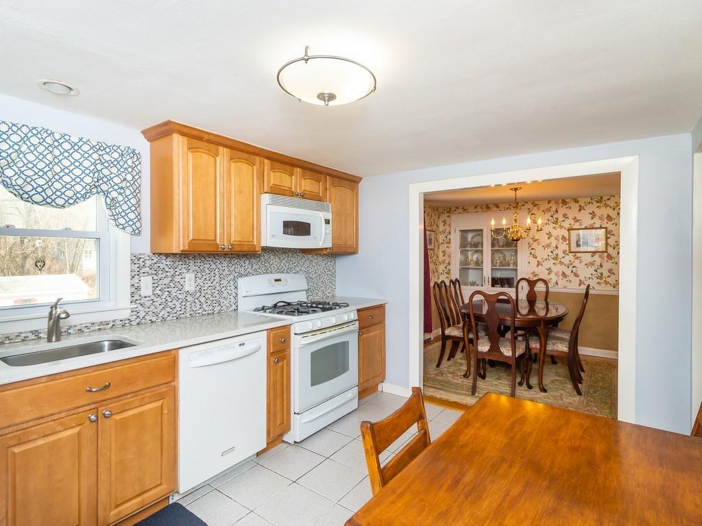 48 MacDonald Circle Walpole, MA 02081 - Photo 12 of 41 a kitchen with stainless steel appliances granite countertop a stove top oven a sink dishwasher a dining table and chairs with wooden floor