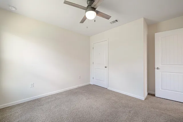 an empty room with a ceiling fan and a fan