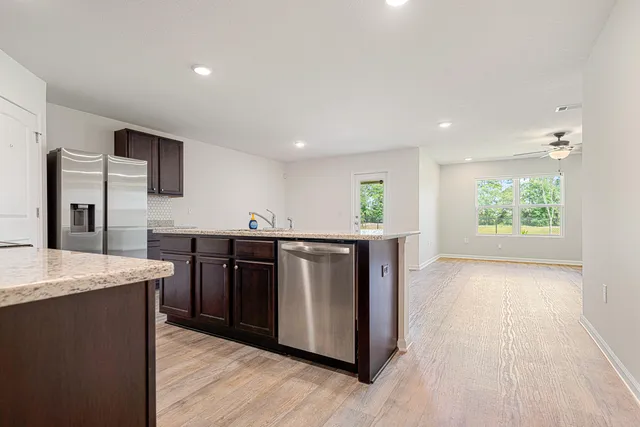 a kitchen with stainless steel appliances granite countertop a sink and a stove