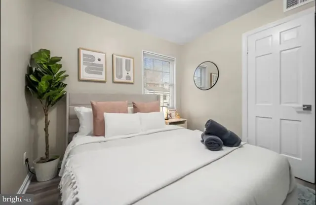 a bedroom with a bed and a potted plant