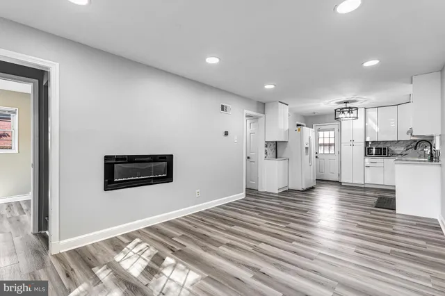 a view of a kitchen with a refrigerator wooden floor and a window