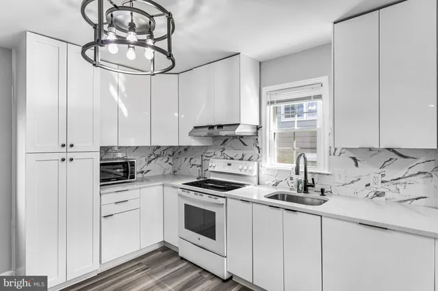 a kitchen with white cabinets and white appliances