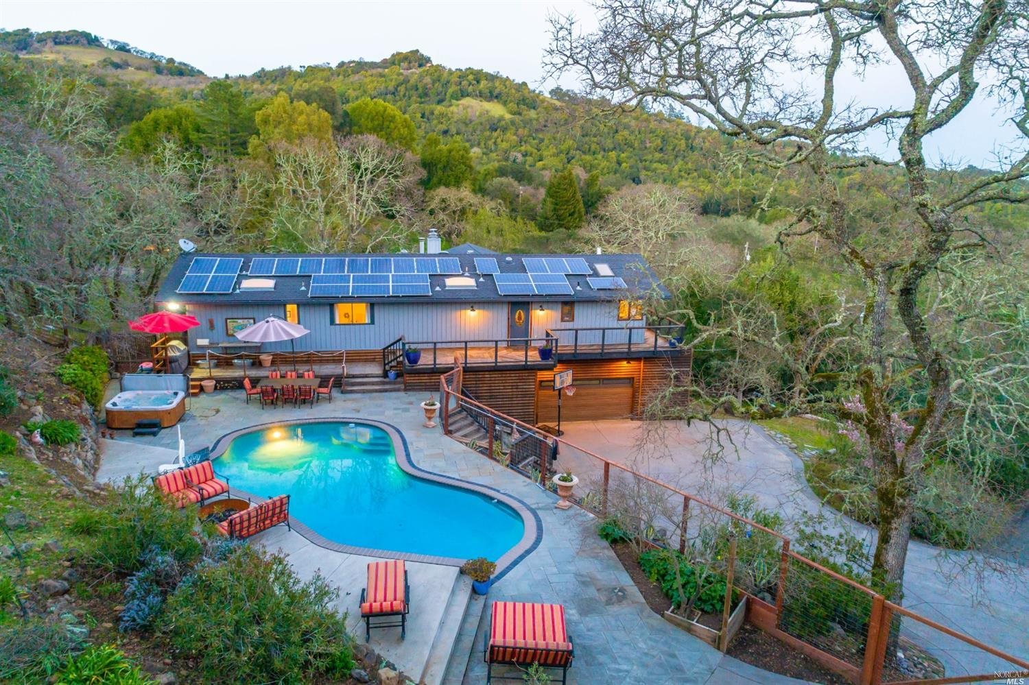 an aerial view of a house swimming pool patio and mountain view
