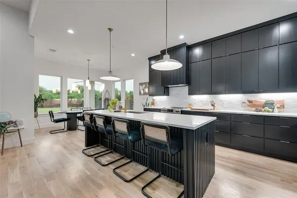 a kitchen with stainless steel appliances granite countertop a sink a stove and a wooden floors