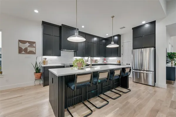 a kitchen with stainless steel appliances granite countertop a kitchen island a stove and a sink