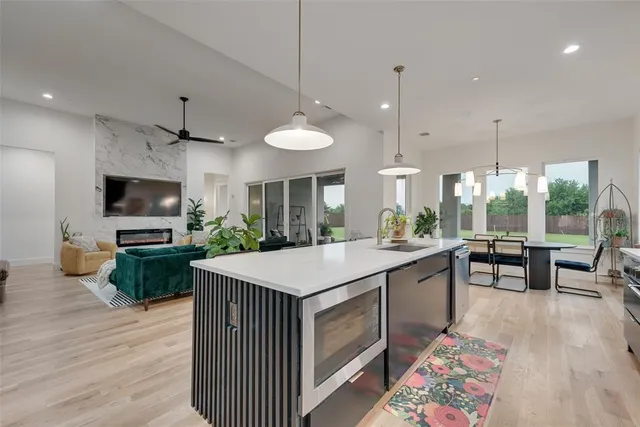 a large kitchen with kitchen island a sink table and chairs