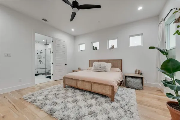 a spacious bedroom with a bed and ceiling fan