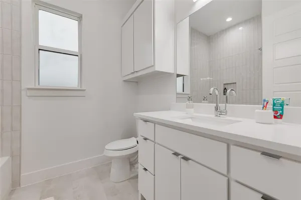 a bathroom with a toilet a sink and mirror