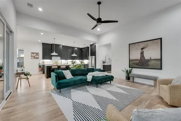 a living room with furniture and a view of kitchen